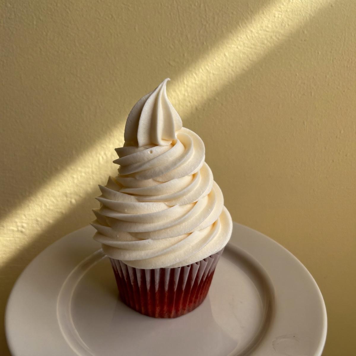 A single frosted cupcake on a plate.